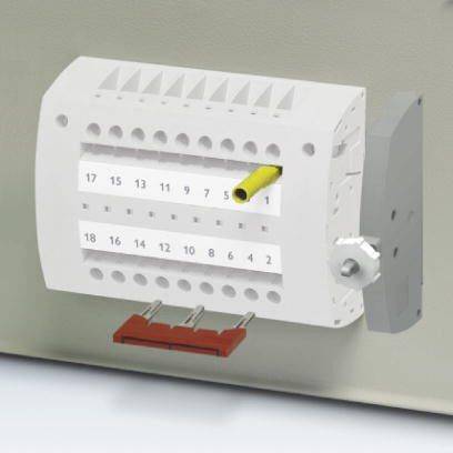Elektrische Klemmleiste mit nummerierten Anschlüssen, ein Kabel angeschlossen an Anschluss 5, an einer Wand montiert.