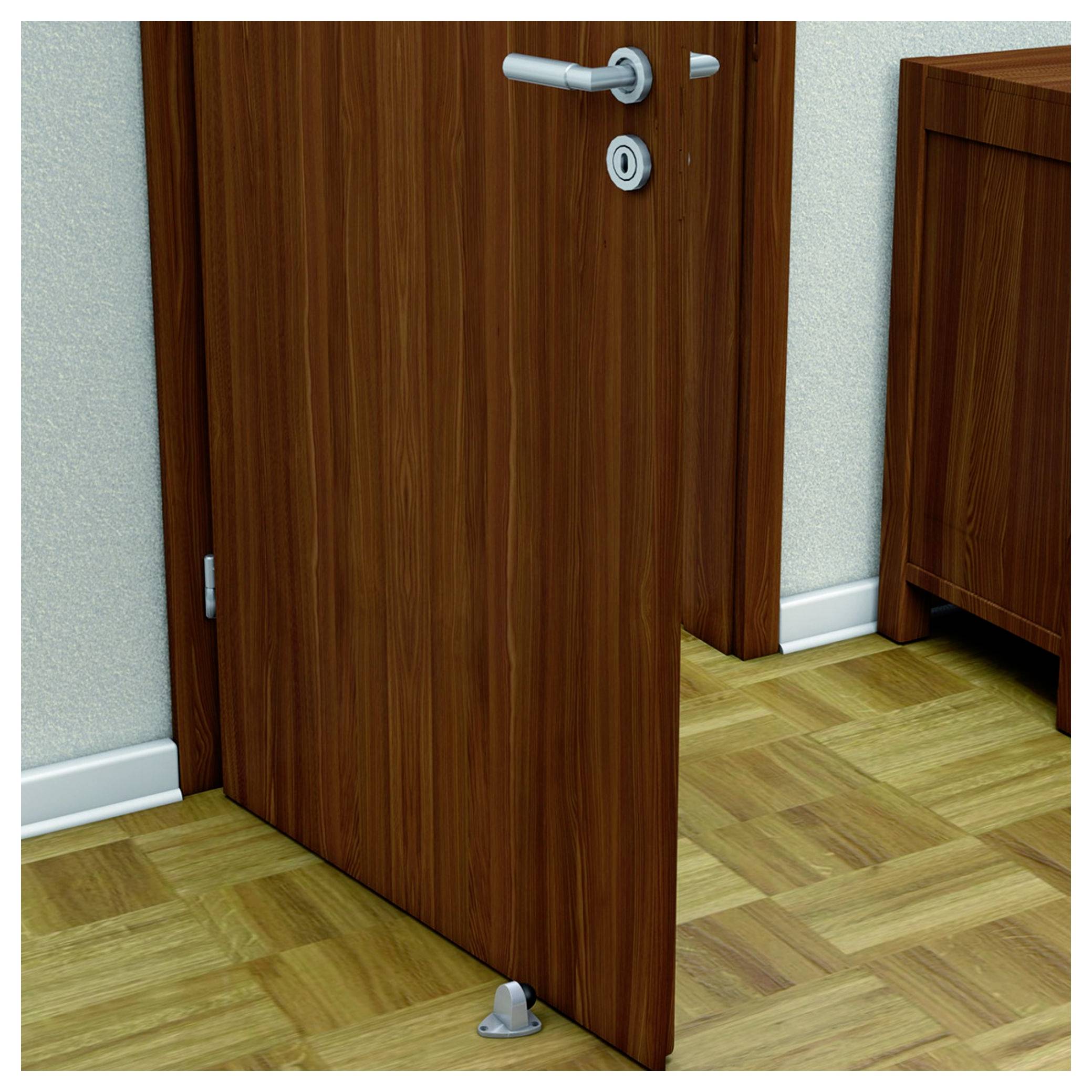 Eine leicht geöffnete Holztür auf Parkettboden, gehalten durch einen metallenen Türstopper. Im Hintergrund ist ein Möbelstück sichtbar.