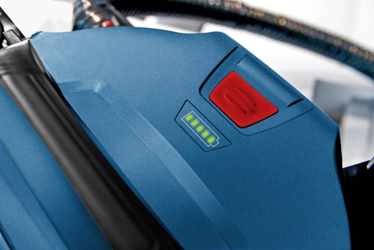 Blauer Staubsauger mit roter Taste und grünem Batteriestatusanzeige.