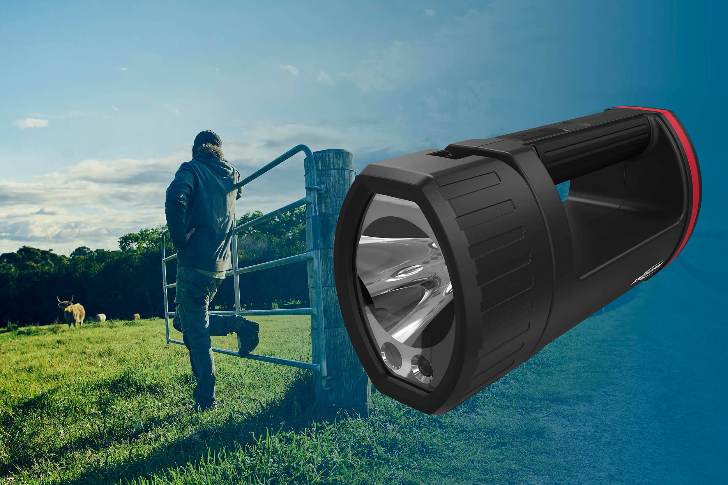 Ein Mann öffnet ein Weidetor auf einer Wiese, während eine große Taschenlampe den Vordergrund dominiert. Links im Hintergrund ist ein Hirsch zu sehen.