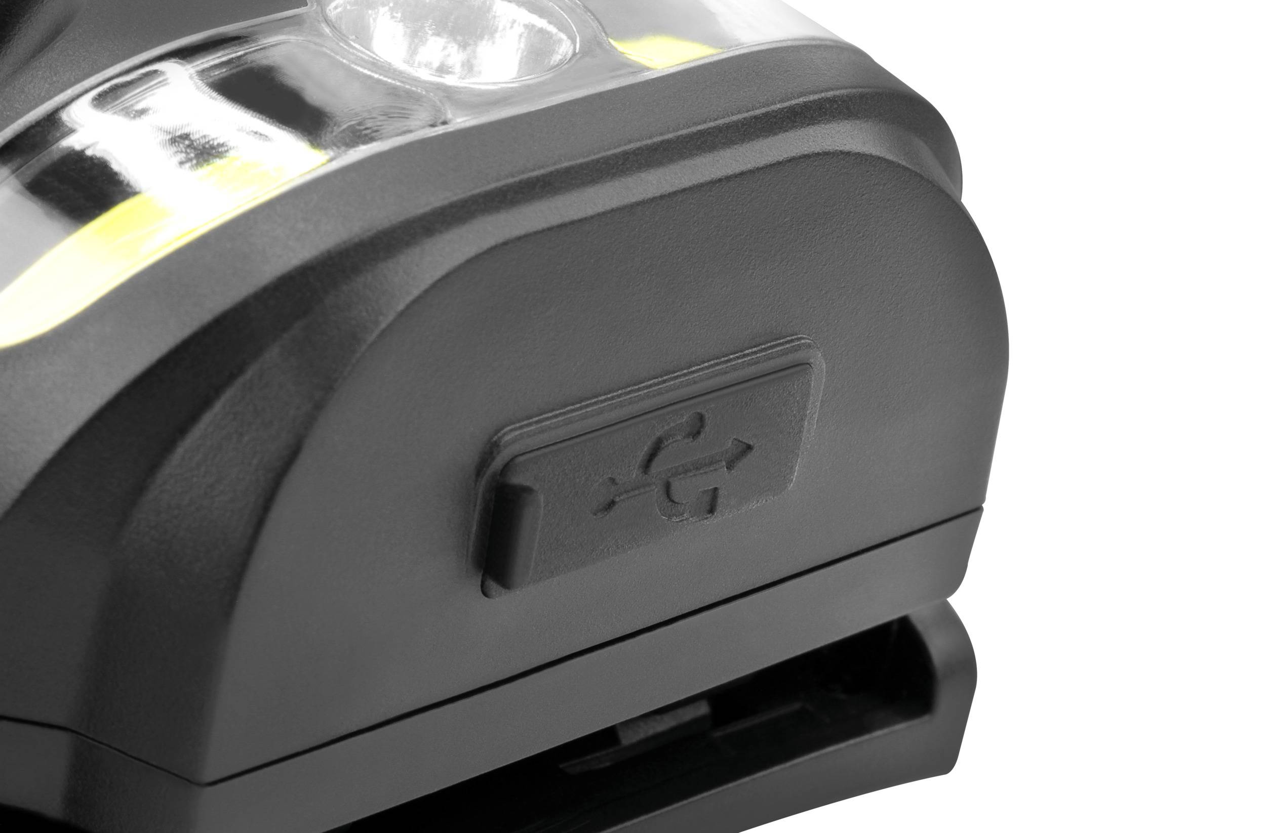 Ein schwarzes Elektrogerät mit einem Fach und einem Schiebemechanismus. Darauf befindet sich ein USB-Symbol.