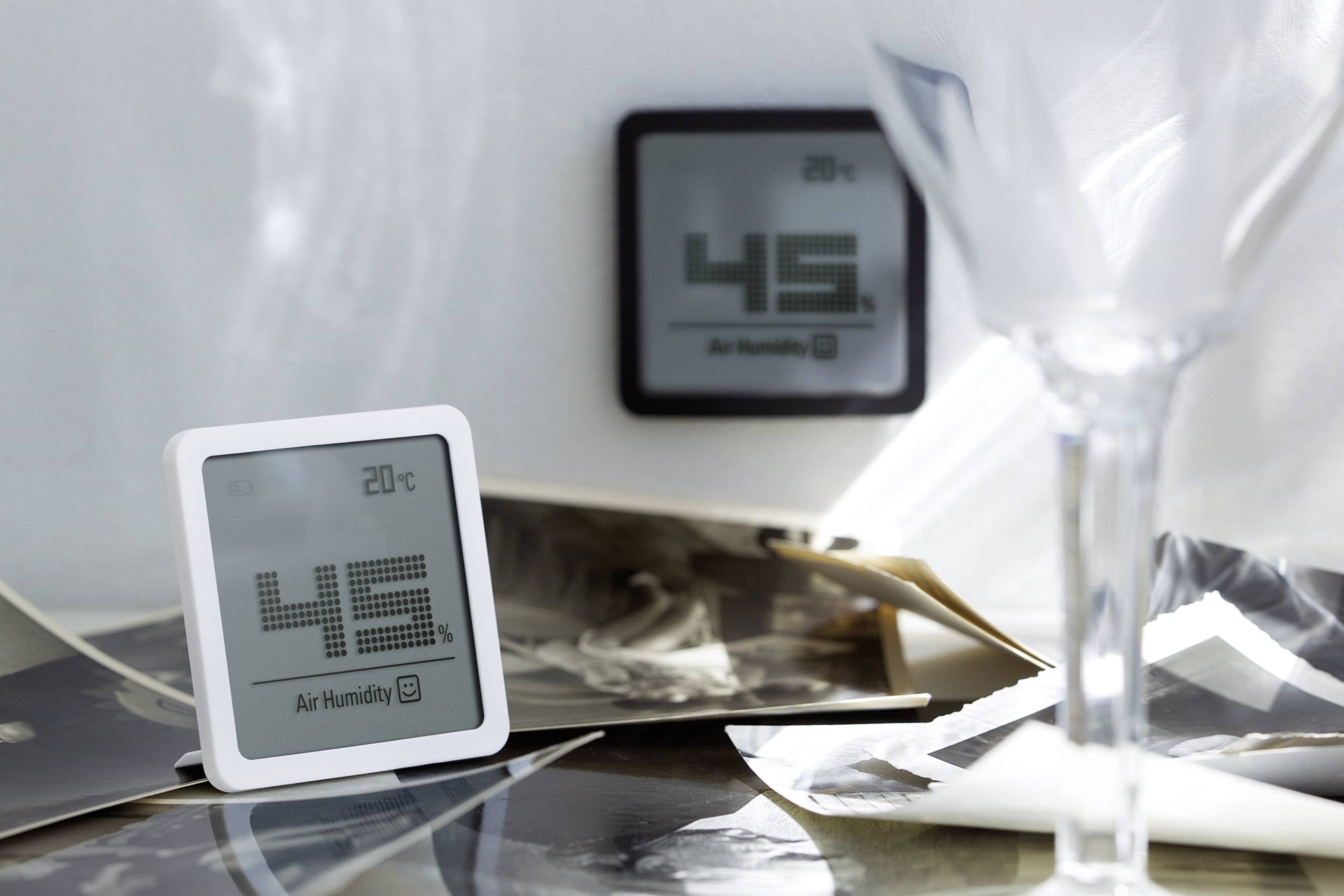 Ein digitales Hygrometer zeigt 45% Luftfeuchtigkeit und 20°C Temperatur an. Im Hintergrund ein weiteres Gerät mit ähnlichen Werten.