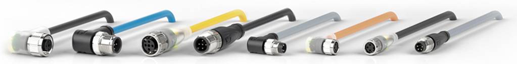 Mehrere elektronische Steckverbinder, unterschiedlich groß und farbig, liegen nebeneinander auf einer weißen Oberfläche.