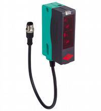 Ein rechteckiger Sensor mit schwarzem Kabel und Stecker. Der Sensor hat ein grün-schwarzes Gehäuse und rote Lichter vorne.