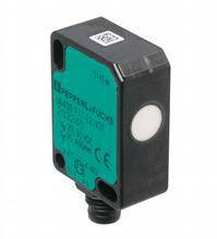 Ein kompakter schwarzer Sensor mit grüner Etikettierung, zeigt CE-Kennzeichnung und technische Details, wie Spannung und Stromstärke.