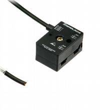 Ein schwarzer, rechteckiger elektronischer Sensor mit einem Kabel. Oben sind Kontroll- und Einstellmarkierungen sichtbar.