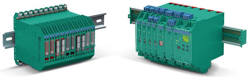 Zwei grüne elektronische Module nebeneinander montiert. Links mehrere Buchsen, rechts Zylinder und Schalter. Montiert auf DIN-Schienen.