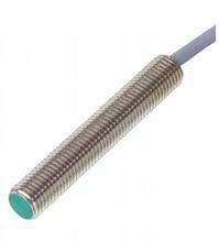 Ein zylindrischer, metallischer Sensor mit einem grünen Ende. Ein Kabel ist am Sensor befestigt und führt nach rechts.
