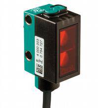 Ein rechteckiger elektronischer Sensor mit schwarzem Gehäuse und rotem Fenster, abgebildet vor einem weißen Hintergrund.