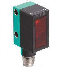 Ein rechteckiger optoelektronischer Sensor mit grünem Gehäuse und rotem Panel. Der Sensor hat Anschlüsse an der Unterseite.