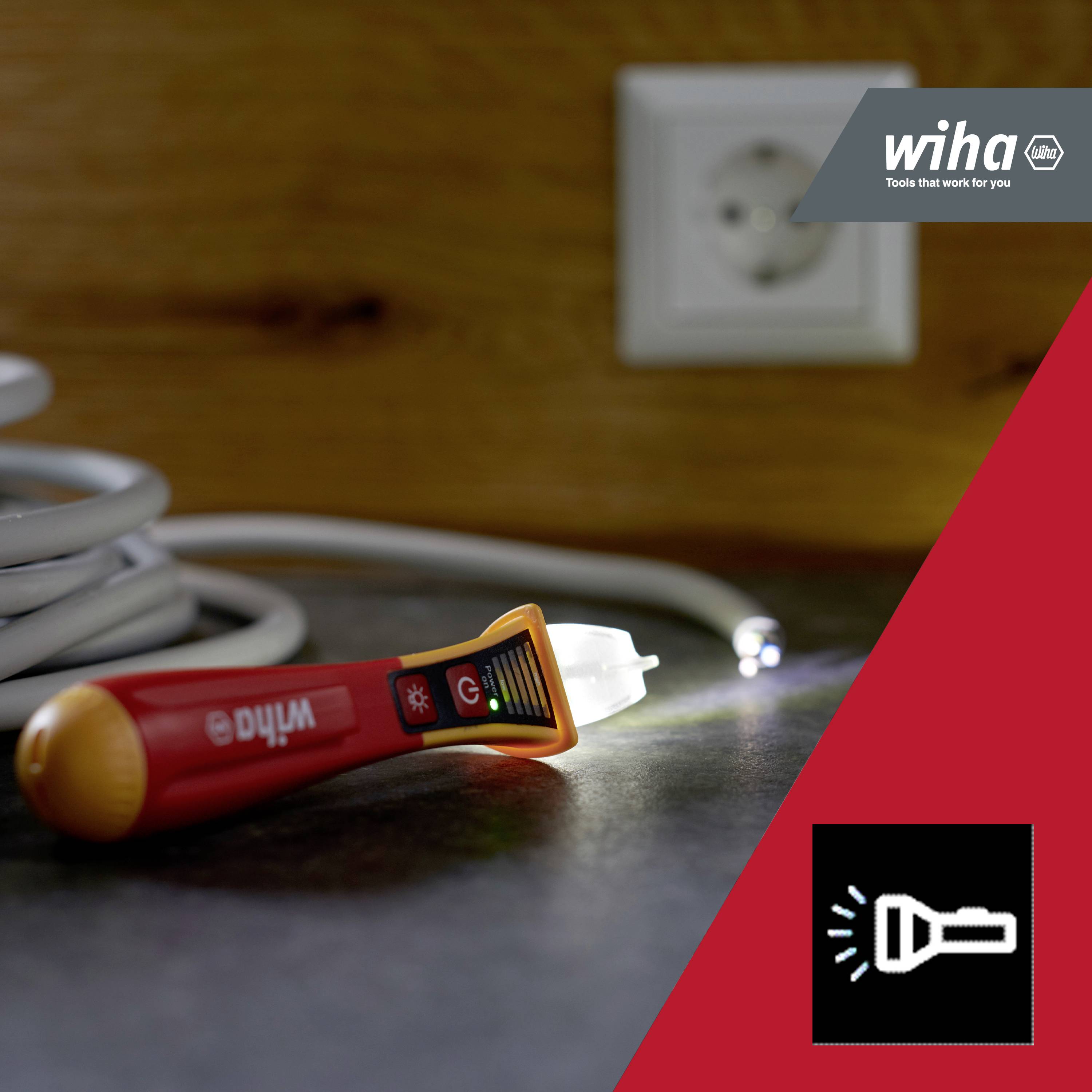 Steckdose, Kabel und leuchtender Spannungsprüfer auf einem Tisch; im Hintergrund das Logo von Wiha, Werkzeughersteller.