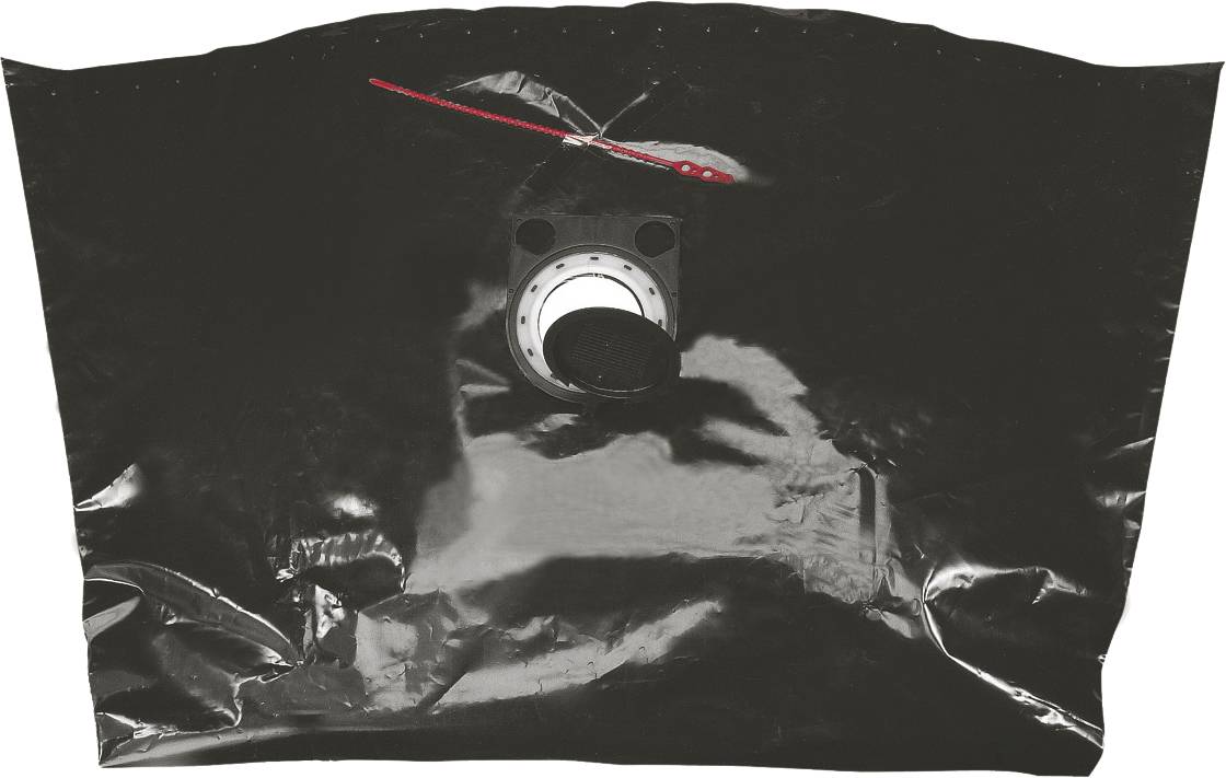 Schwarze Plastiktüte mit rundem Ventil in der Mitte und rotem Verschluss oben.