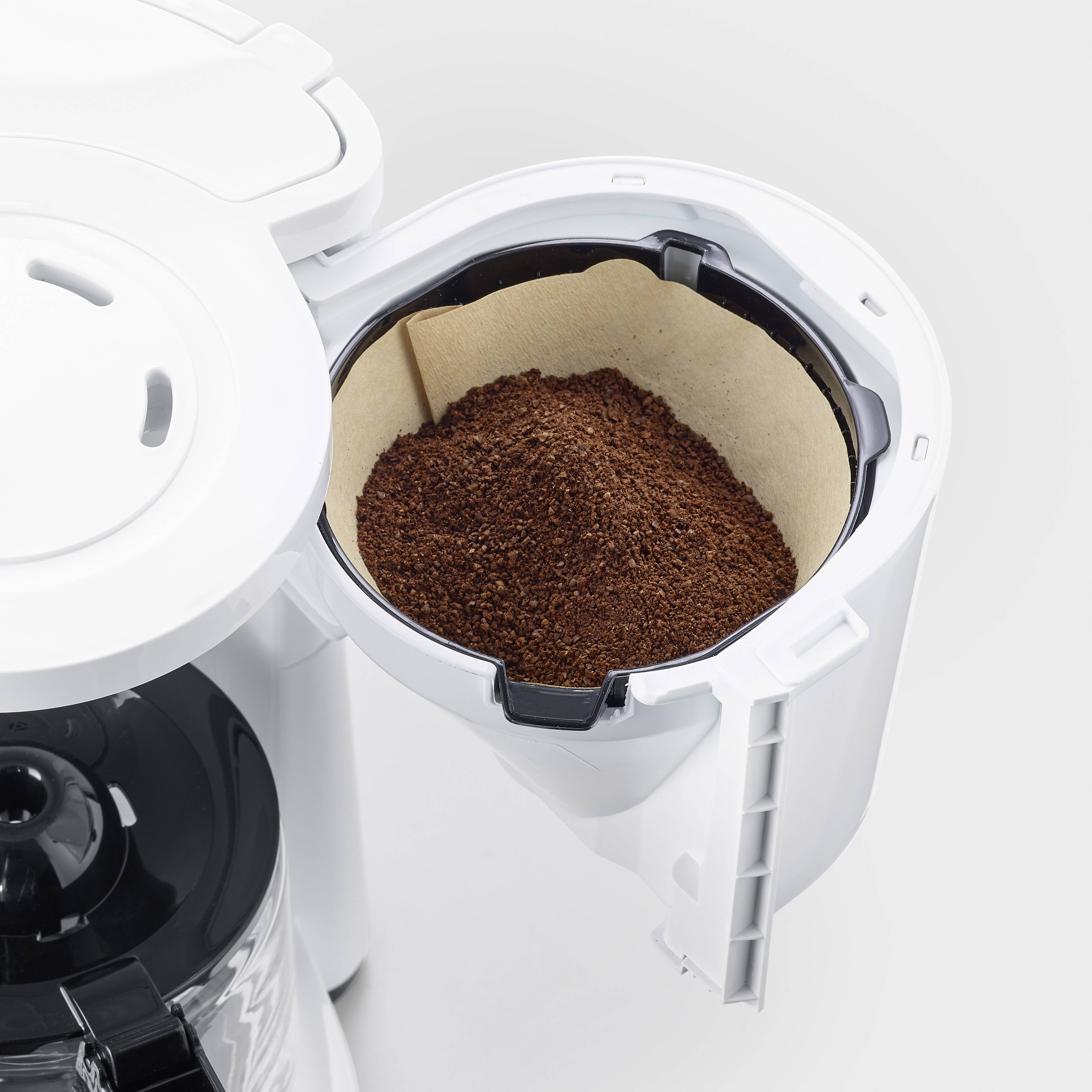 Kaffeemaschine mit geöffnetem Filterfach, gefüllt mit Kaffeepulver.