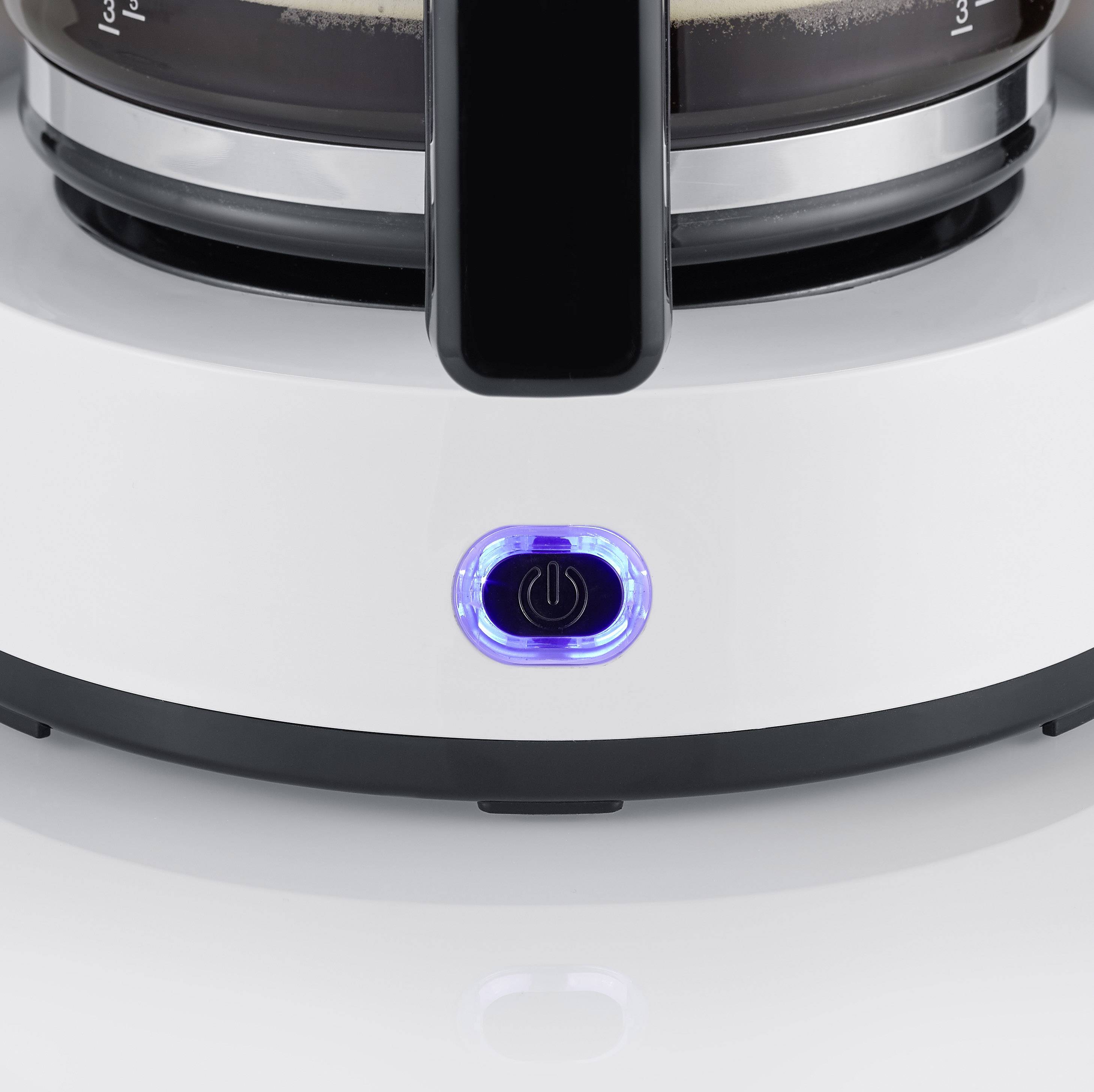 Ein weißer Kaffeeautomat mit blau leuchtendem Einschaltknopf, Kaffee tropft in eine gläserne Kanne darunter.