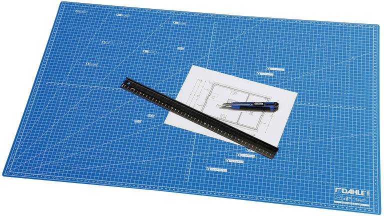 Ein blaues Schneidematte mit Millimeter-Raster, darauf ein Lineal, ein Architekturplan und ein Schneidemesser.