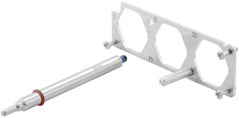 Zylindrisches Metallwerkzeug und rechteckiger Rahmen mit Schraubenlöchern, möglicherweise Teil eines technischen oder mechanischen Geräts.