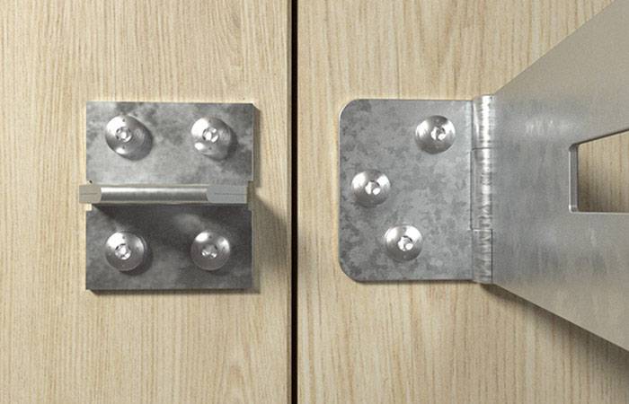 Metallscharnier und Verriegelung an einer Holztür, Nahaufnahme. Links das Scharnier, rechts die Verriegelung auf heller Holzoberfläche.