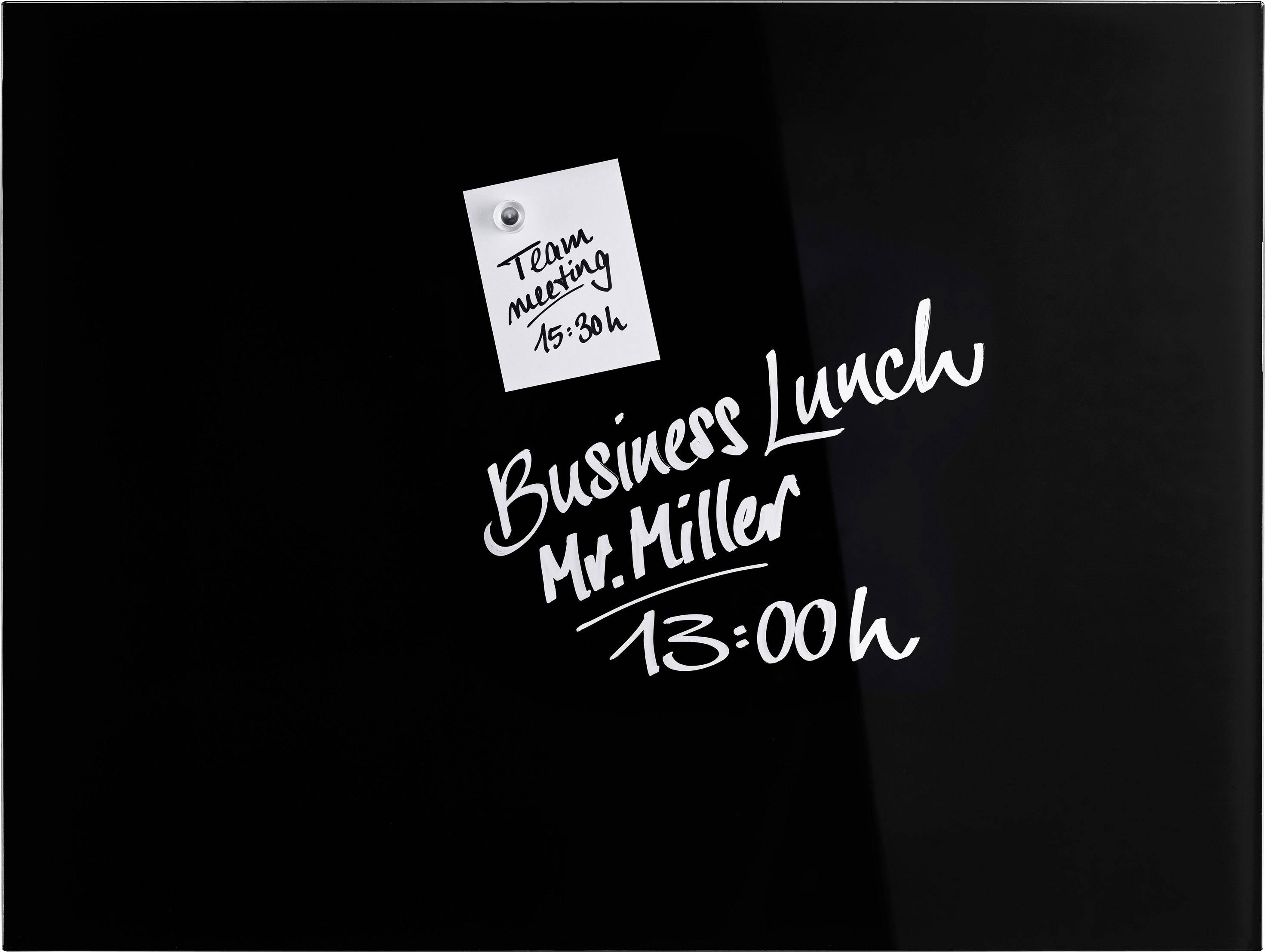'Business Lunch Mr. Miller 13:00h' und 'Team meeting 15:30h' sind auf einem schwarzen Hintergrund handgeschrieben. Ein Notizzettel hängt daneben.