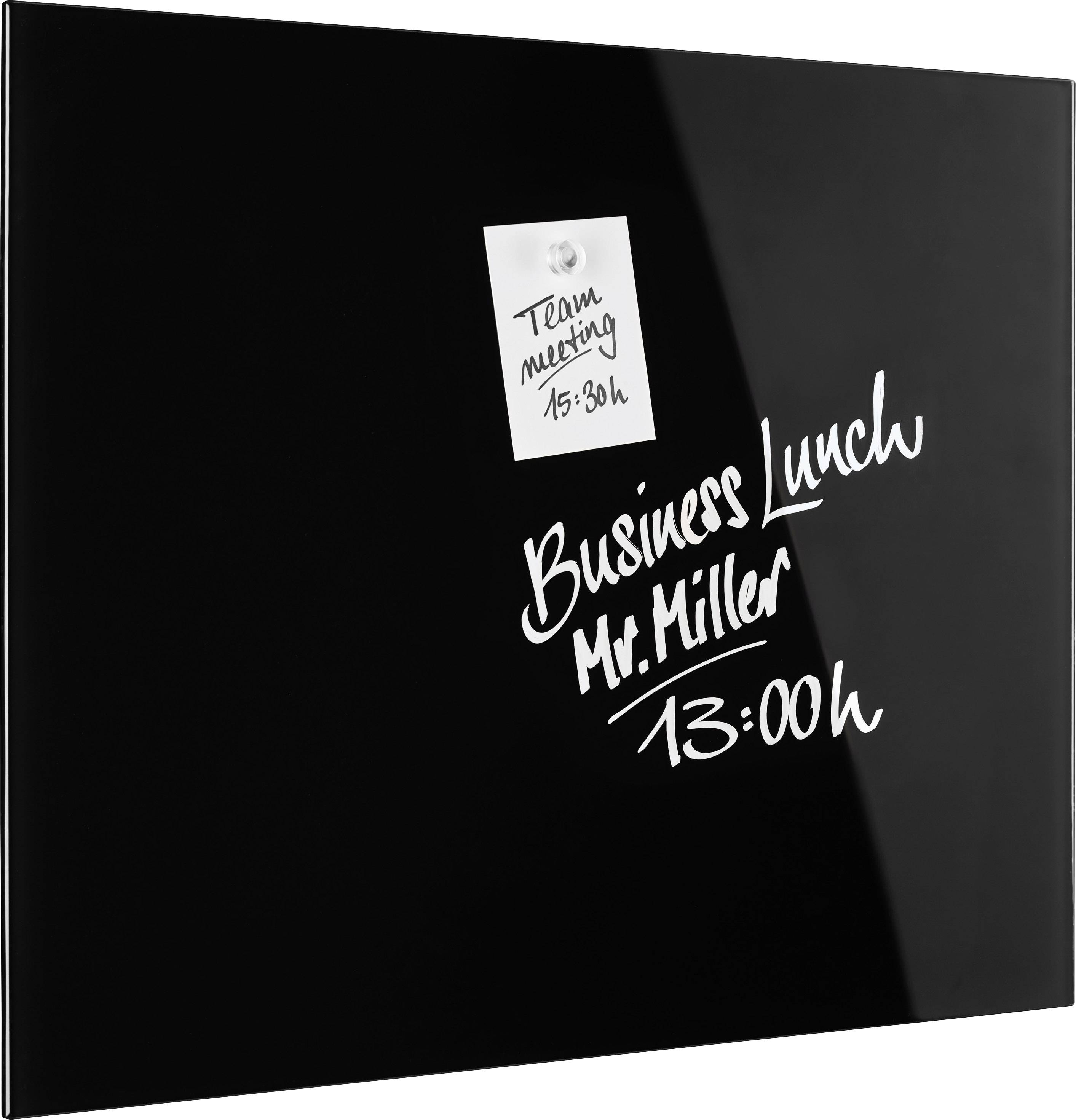 Schwarzes Pinnwand-Board mit zwei handgeschriebenen Notizen: 'Team meeting 15:30h' und 'Business Lunch Mr. Miller 13:00h'.