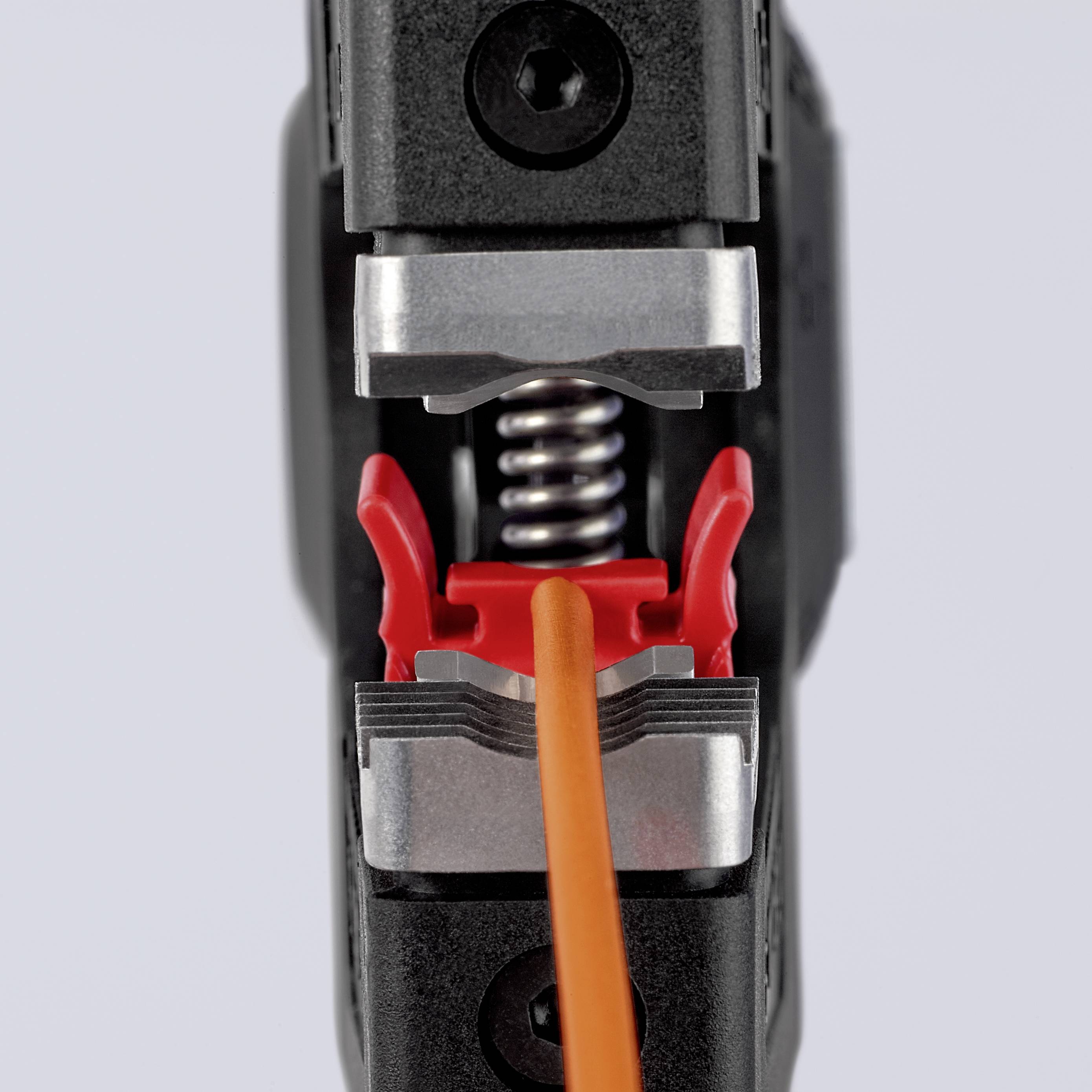 Nahaufnahme eines Werkzeugs, das ein orangefarbenes Kabel festhält, mit metallischen und roten Kunststoffkomponenten.