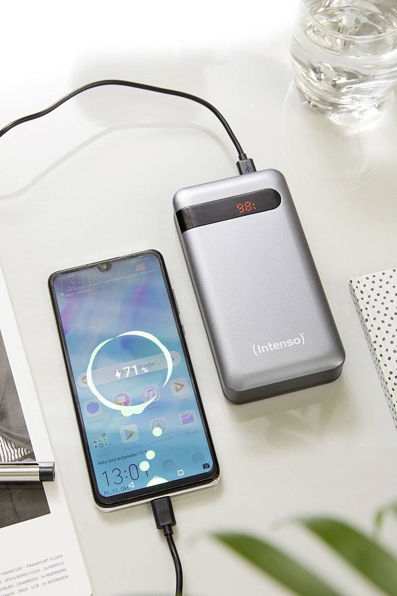 Smartphone wird von einer grauen Powerbank aufgeladen. Auf dem Display des Smartphones steht '71%'. Powerbank zeigt '98%' an.