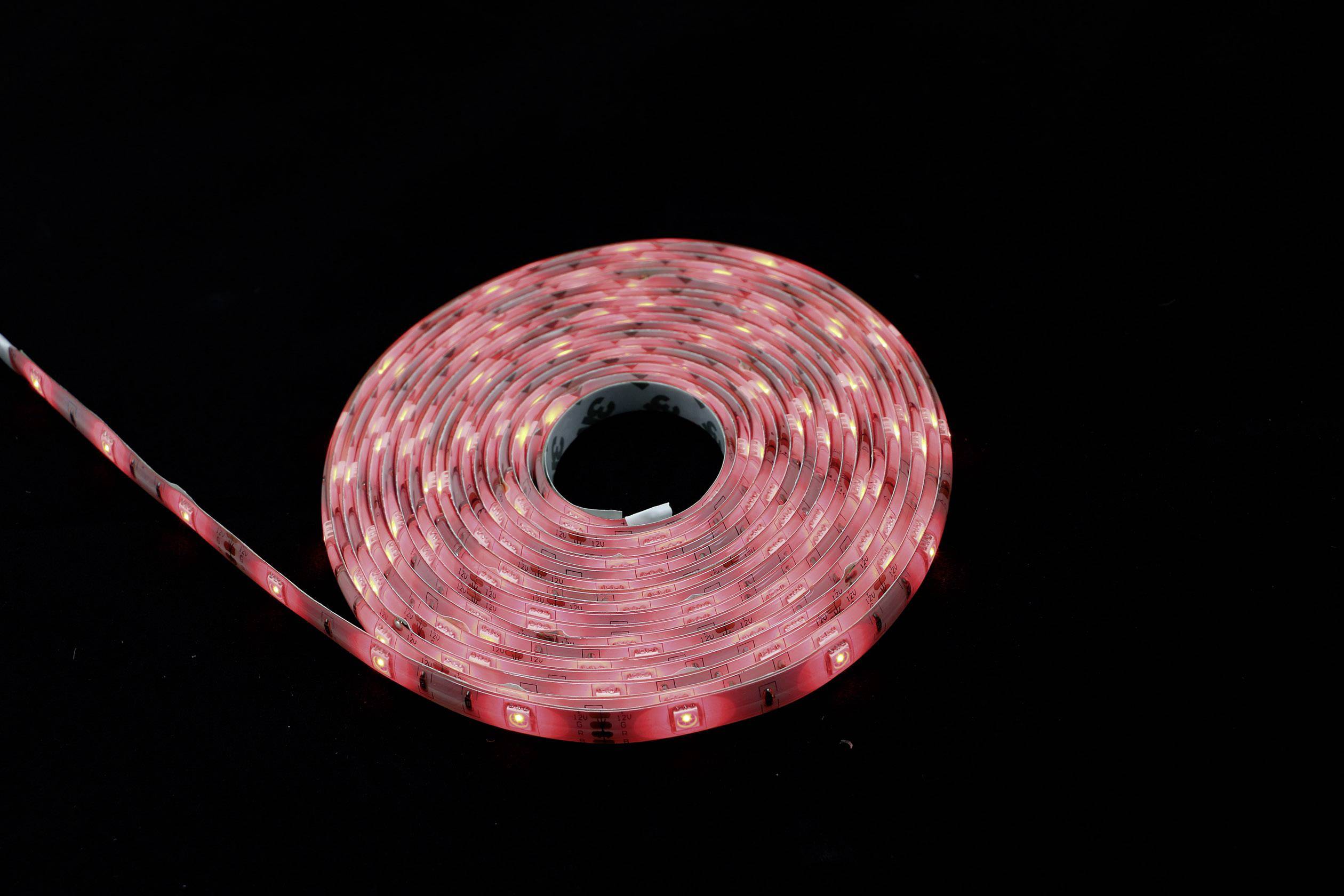 Eine aufgerollte, leuchtende rote LED-Lichtleiste auf schwarzem Hintergrund, zeigt flexible Form und gleichmäßige Lichtverteilung.
