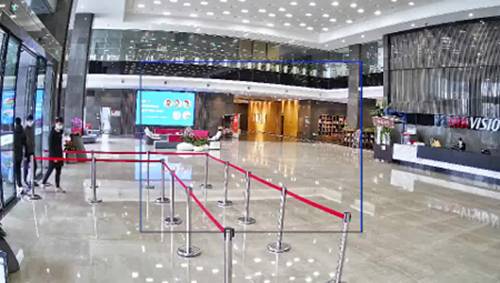 Eingangsbereich eines modern gestalteten Bürogebäudes mit glänzendem Boden und Absperrungen, die einen Weg zum Empfangstresen leiten.