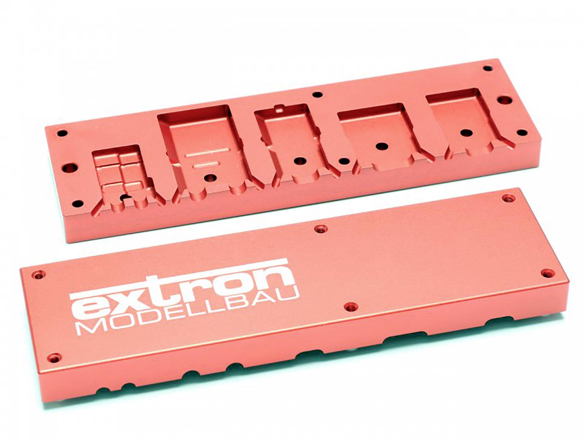 Zwei rote Metallteile, eines mit dem Aufdruck 'extron MODELLBAU'.