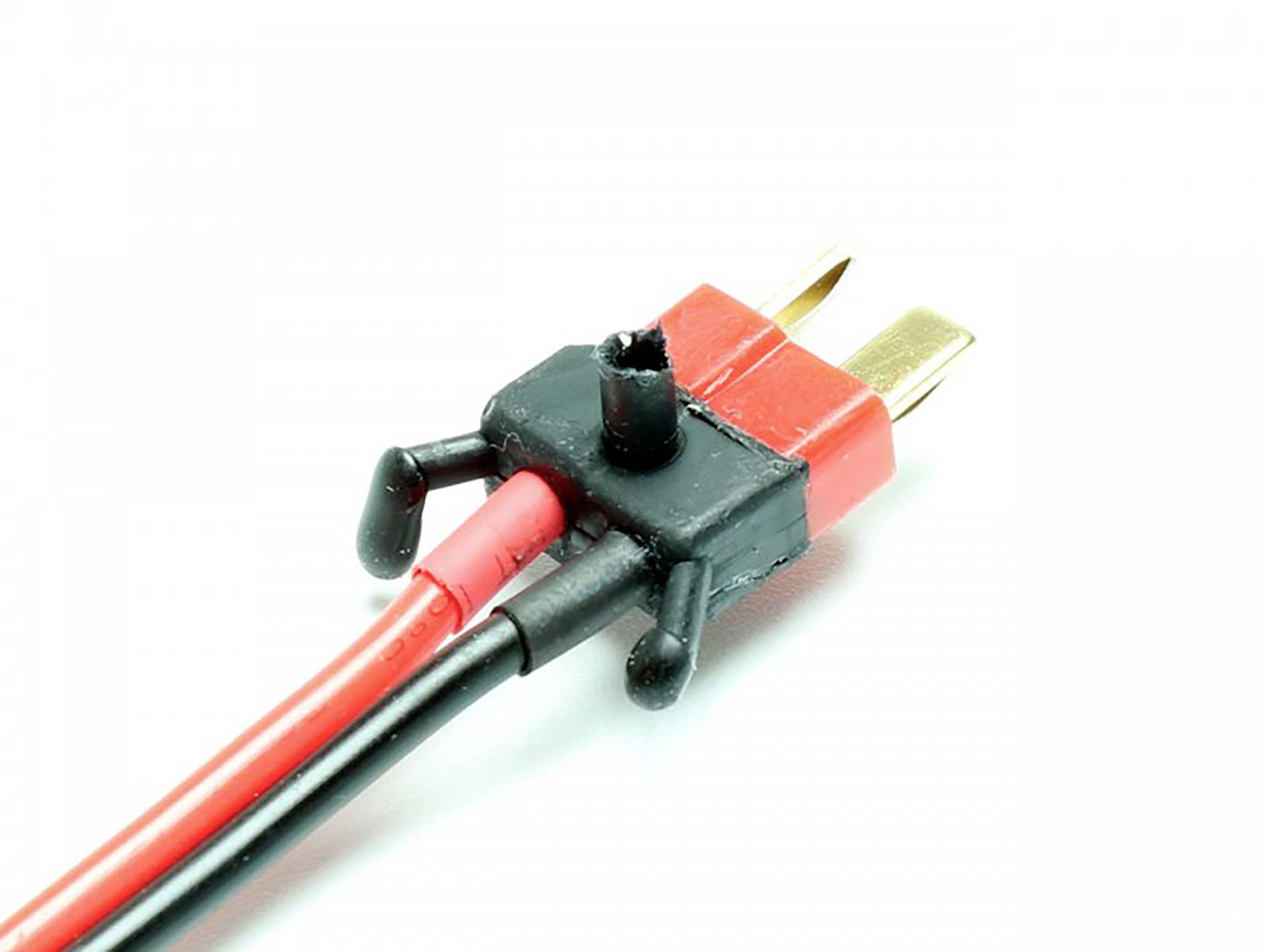 Ein roter und schwarzer Draht sind an einem viereckigen Plastikstecker mit zwei goldenen Metallkontakten befestigt.