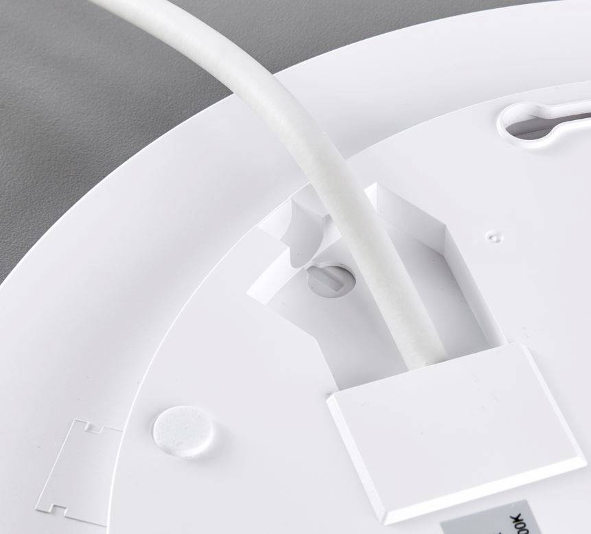 Deckenmontage von elektronischem Gerät, Nahaufnahme: Kabel durch Öffnung geführt, Schraubpunkte sichtbar, auf grauer Oberfläche.