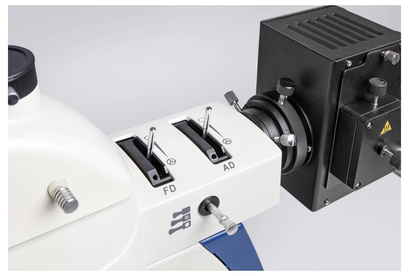 Ein Mikroskop mit zwei Einstellhebeln und einer Kamera-Anschlussvorrichtung, geeignet für präzise wissenschaftliche Untersuchungen.