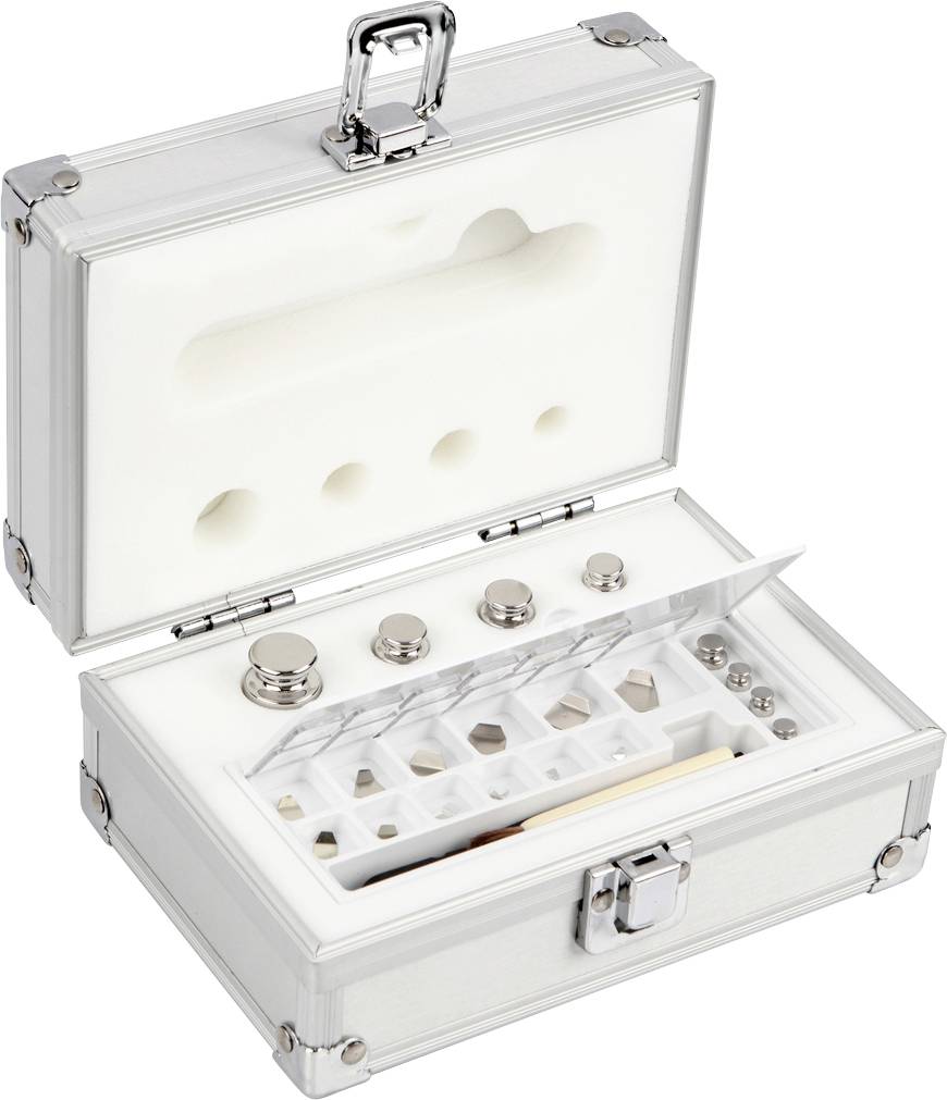 Ein offener Metallkoffer mit Schaumstoffeinlage enthält mehrere Präzisionsgewichte unterschiedlicher Größe.