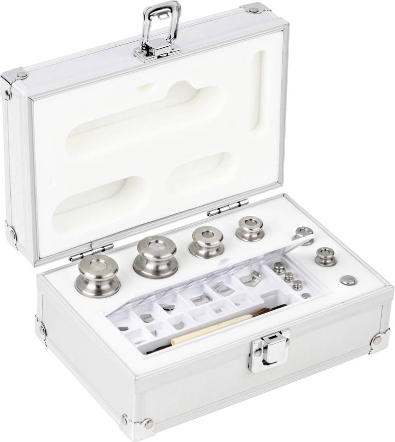 Ein geöffneter Metallkoffer mit verschiedenen Gewichten in Schaumstoffeinlage, darunter runde und zylindrische Formen.