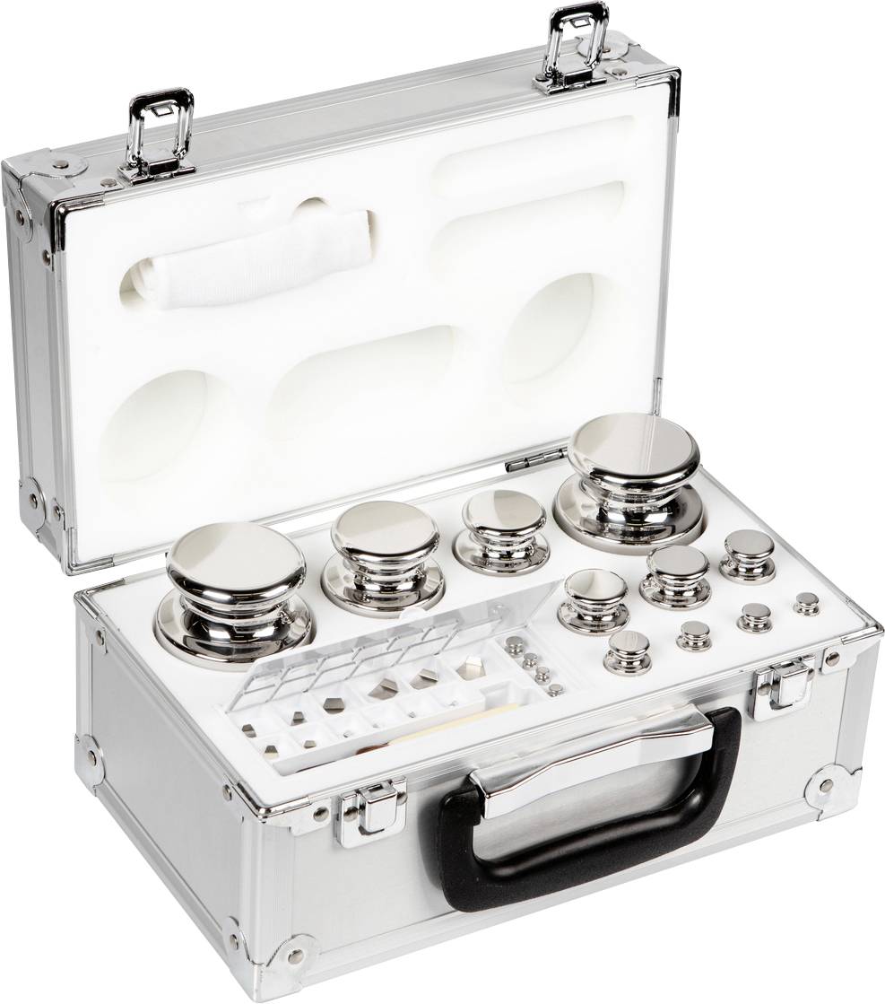 Ein offener Metallkoffer enthält ein Set von Kalibriergewichten unterschiedlicher Größe und Form, angeordnet auf einem weißen Einsatz.