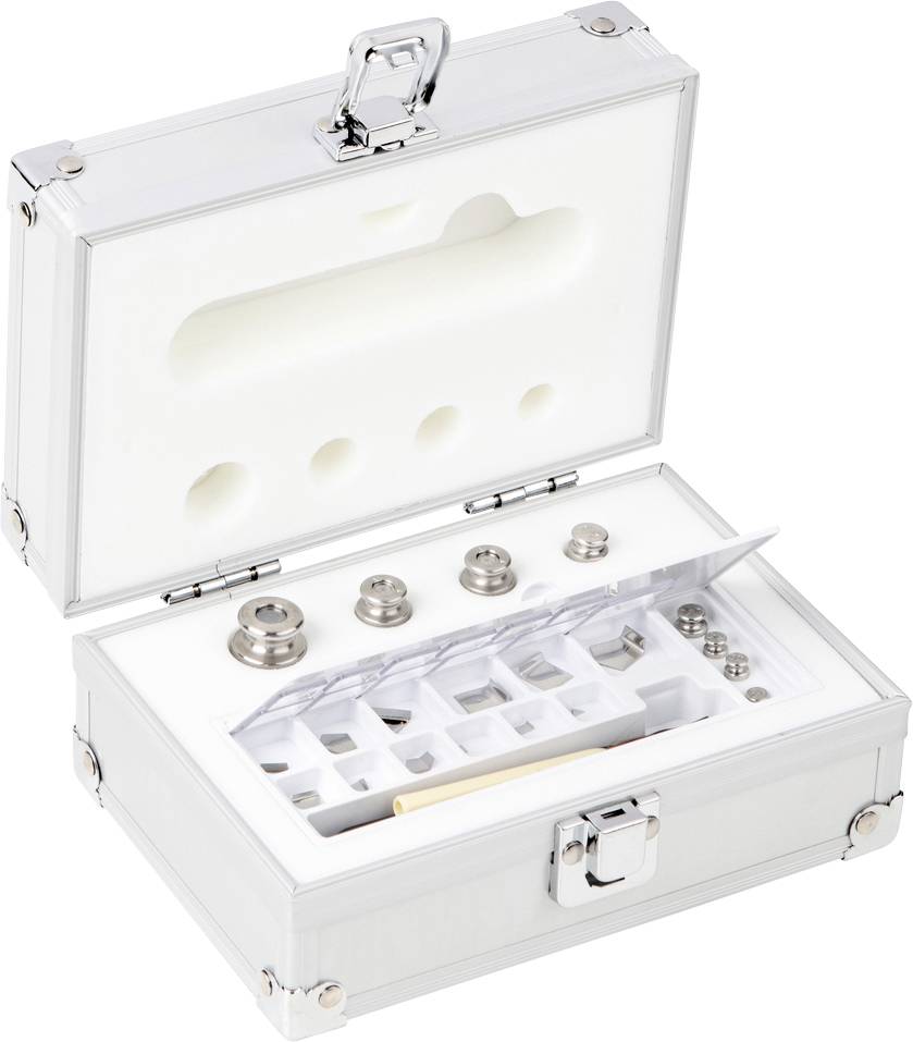 Ein offener, silberner Koffer mit Schaumstoffeinlage zeigt Gewichte aus Metall und Zubehör zur Kalibrierung oder Messung.