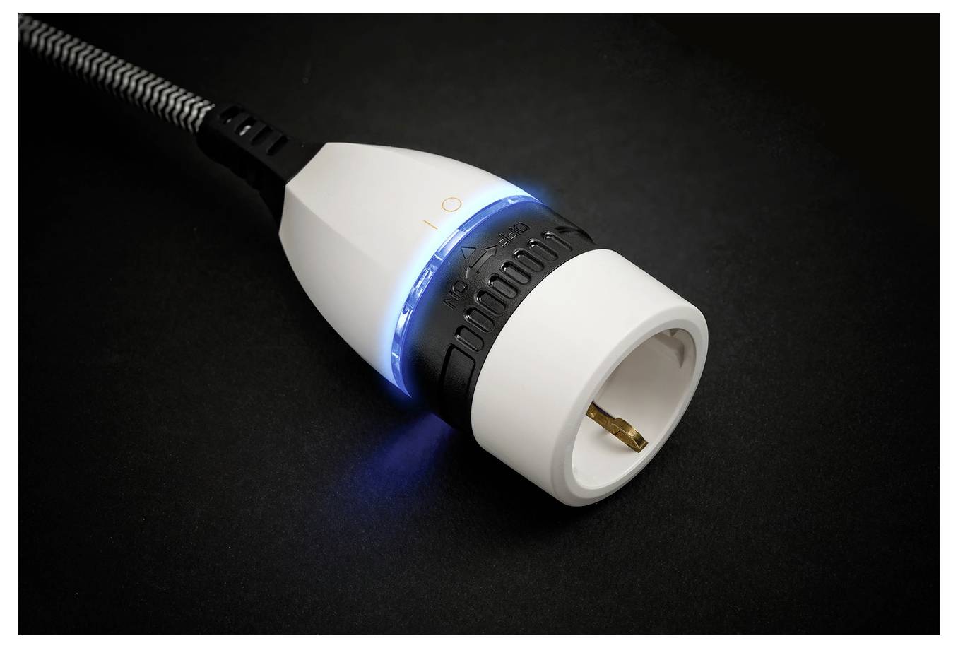Ein weißer intelligenter Stecker mit leuchtendem blauem Ring und geflochtenem Stromkabel auf dunklem Hintergrund.