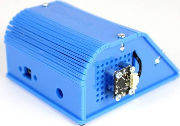 Ein blaues, rechteckiges Elektronikgerät mit Lüftungsschlitzen und einem angeschlossenen kleinen elektrischen Bauteil an der Seite.