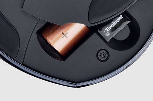 Boden eines Geräts mit geöffneter Abdeckung, zeigt eine eingelegte AA-Batterie und einen USB-Dongle mit der Aufschrift ‚Evoluent‘.