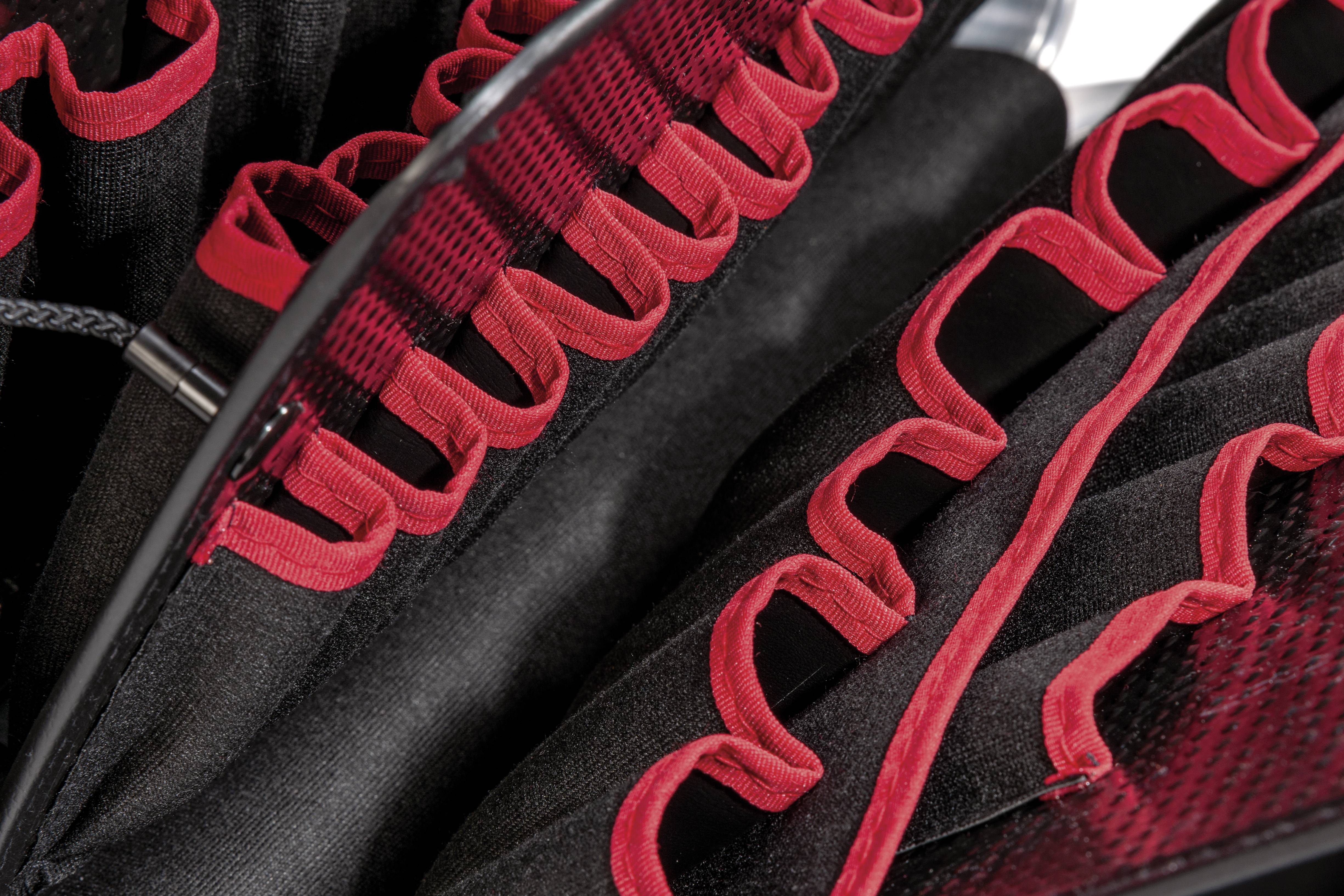 Rotes und schwarzes Stoffgewebe mit Schlaufen und Gitterdesign, Nahaufnahme.