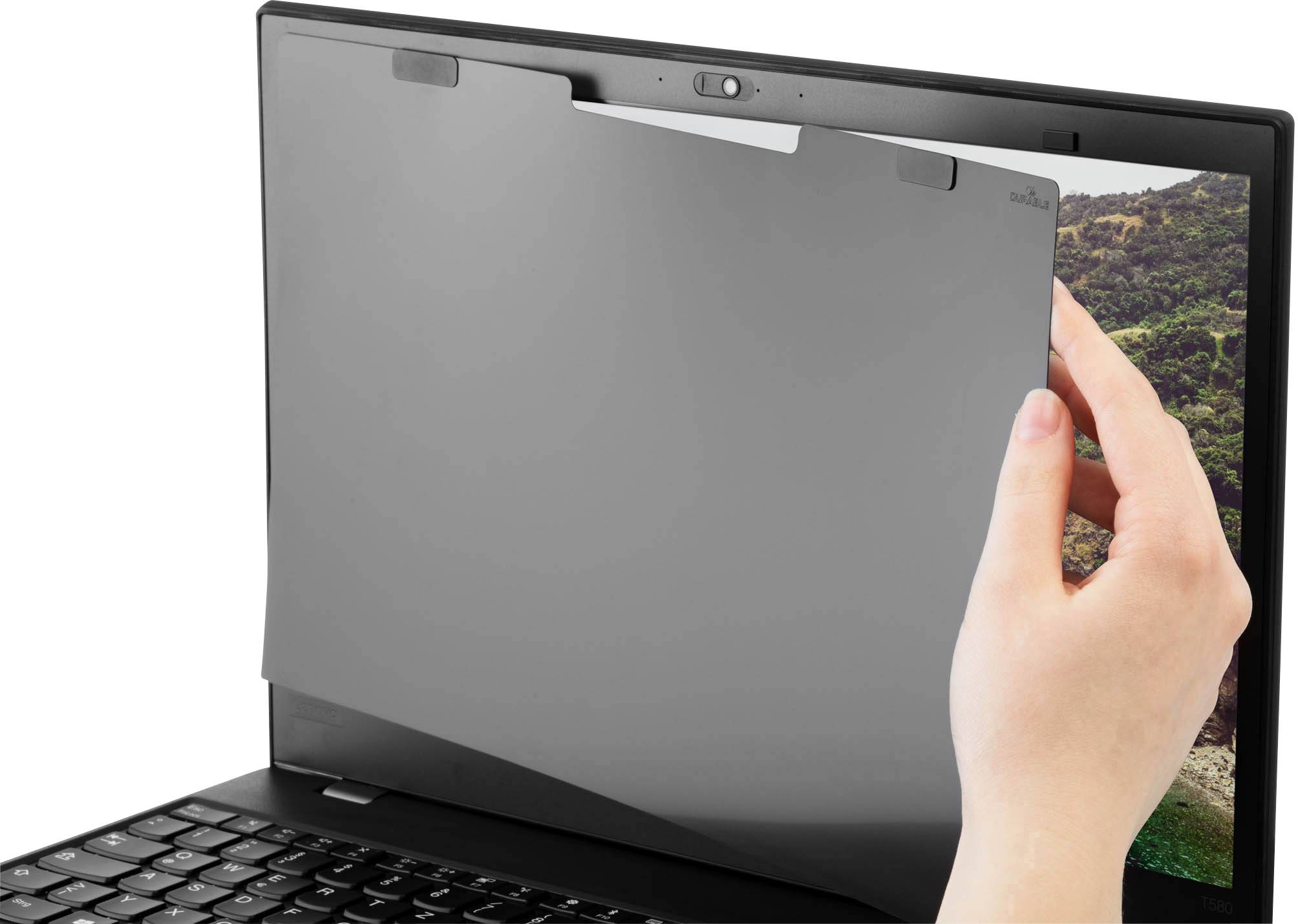 Eine Hand hält einen Blickschutzfilter, der vor dem Bildschirm eines Laptops angebracht wird, um den Inhalt vor neugierigen Blicken zu schützen.