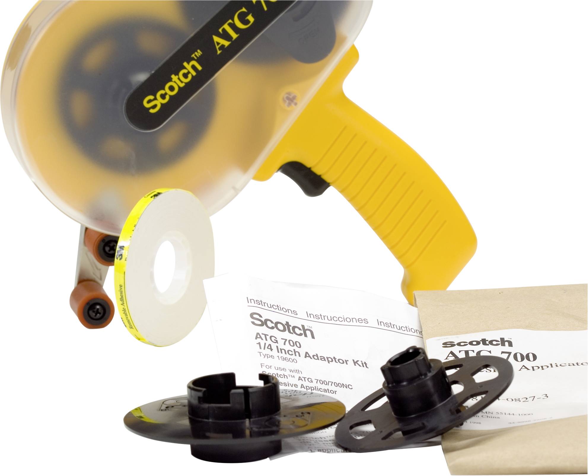 ATG-700-Klebebandspender mit gelbem Griff, umgeben von Klebebandrolle und Adaptern. Beiliegende Anleitung auf mehreren Sprachen.