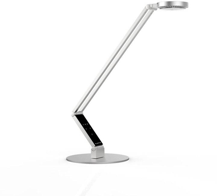 Moderne, silberne Schreibtischlampe mit verstellbarem Arm und rundem Lampenkopf auf einem flachen, kreisförmigen Sockel.