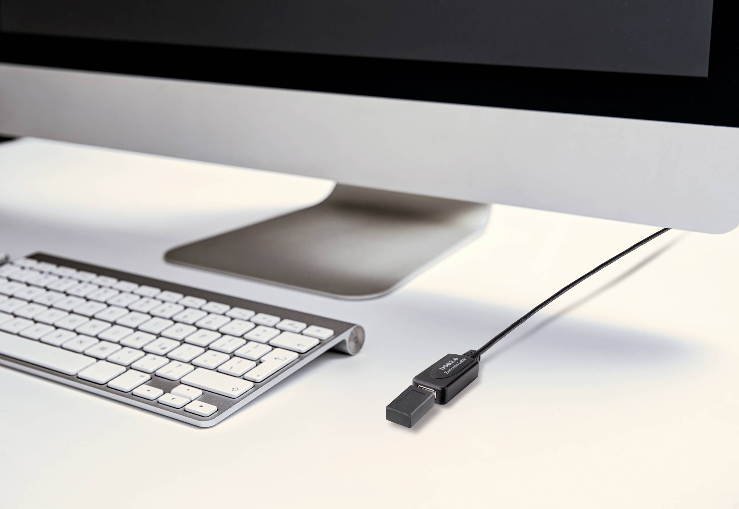 Ein Desktop-Computer zeigt eine angeschlossene kabellose Tastatur und einen USB-Speicherstick, der an der Seite des Monitors eingesteckt ist.