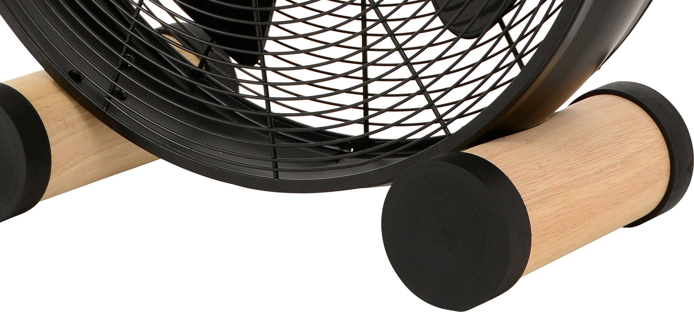 Ein schwarzer Ventilator mit einem Gitter auf zwei zylinderförmigen Holzböcken montiert.
