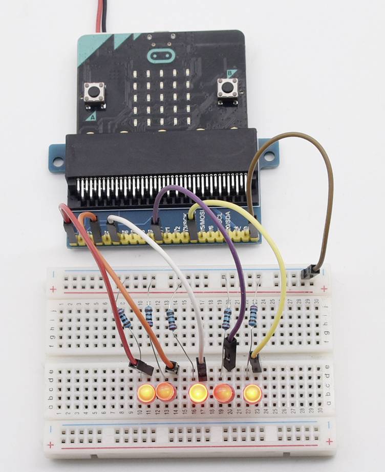 Ein Mikrocontroller ist mit einer Steckplatine verbunden. Auf der Platine leuchten vier LEDs orange. Unterschiedlich farbige Kabel sind verbunden.