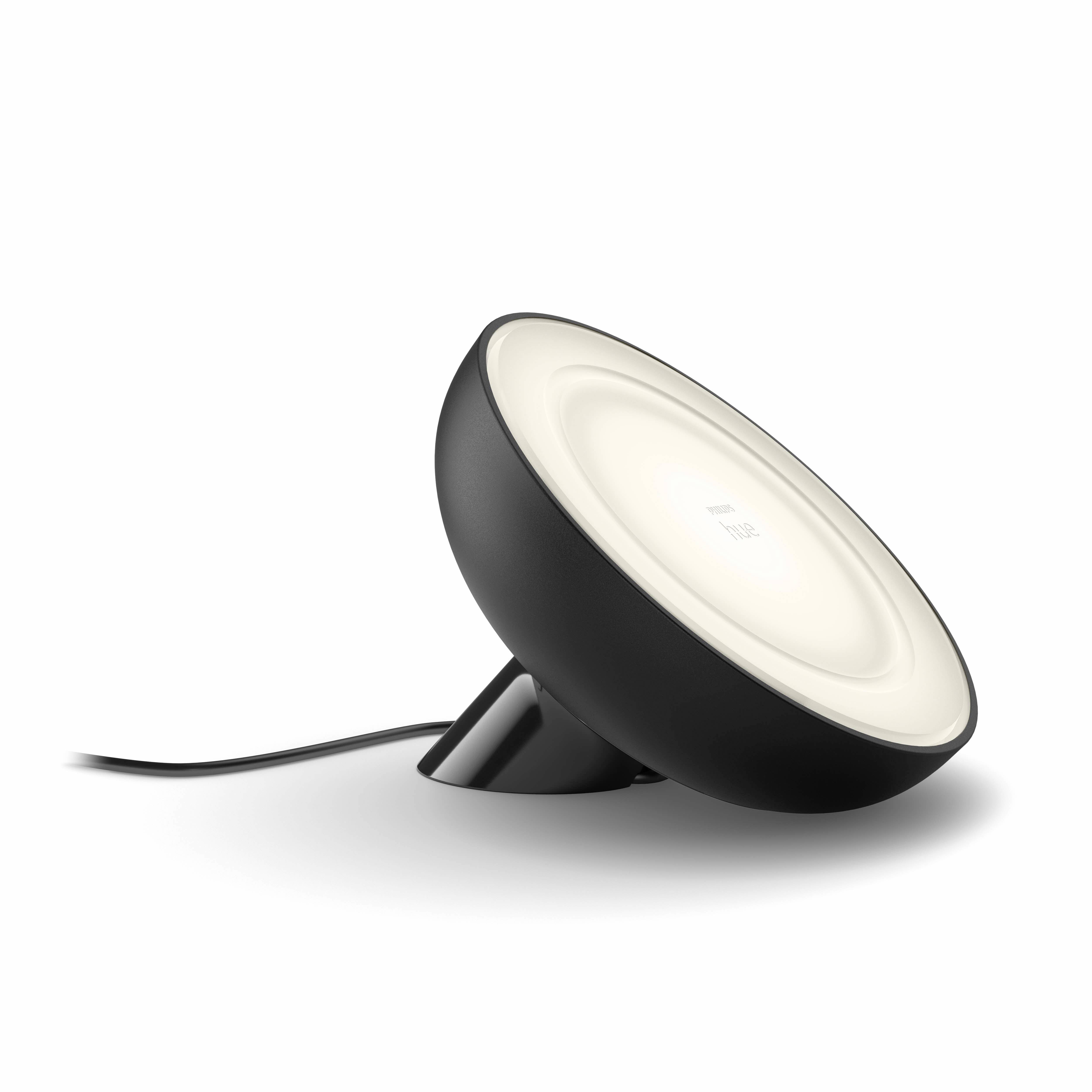 Schwarze, runde Tischlampe mit sanftem Weißlicht, nach oben gerichtet. Stromkabel führt von der Lampe weg.