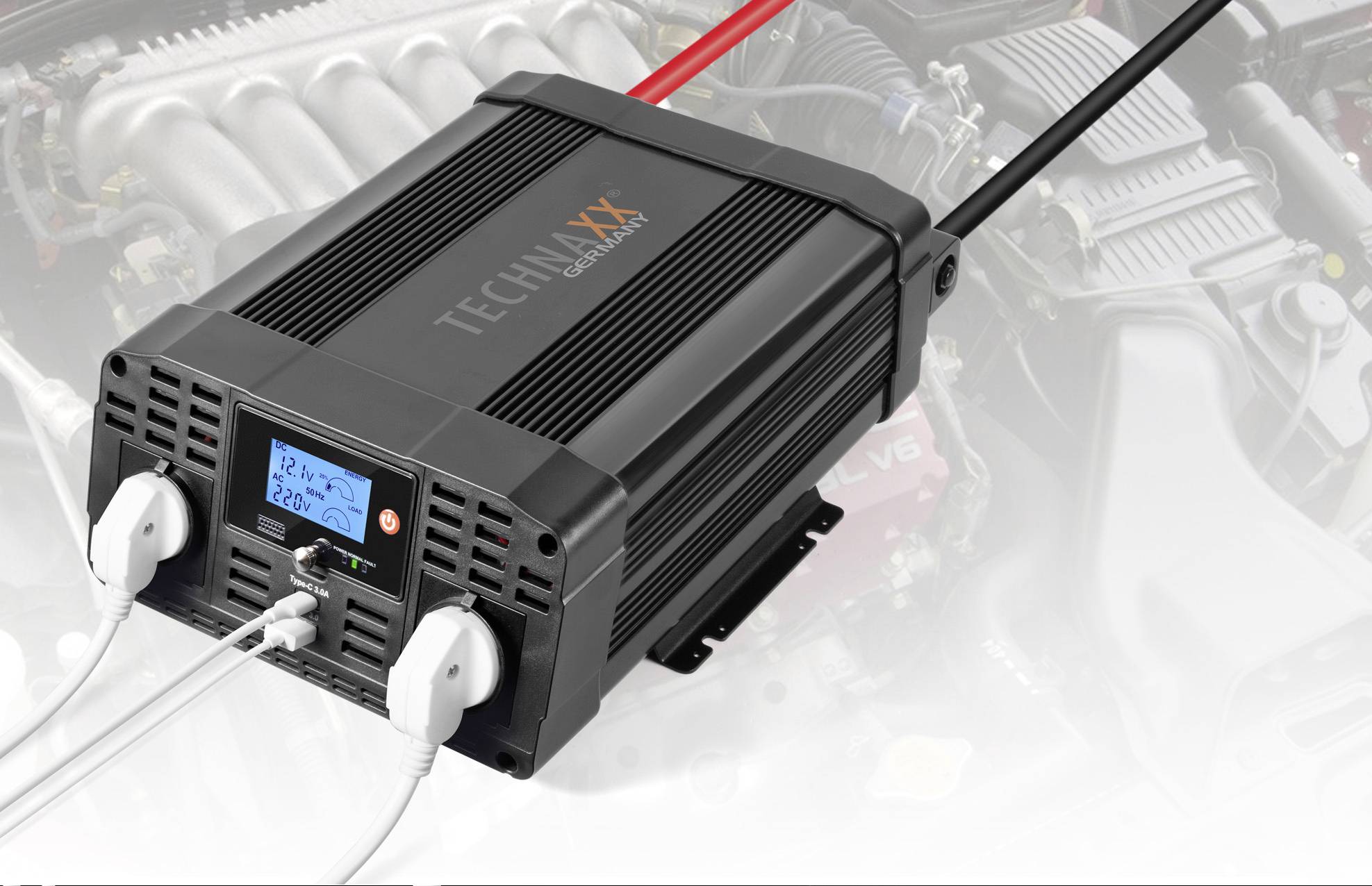 Ein schwarzer Spannungswandler mit Display, das '12,2V 220V' anzeigt, ist an zwei weiße Stecker angeschlossen. Im Hintergrund ein Motor.