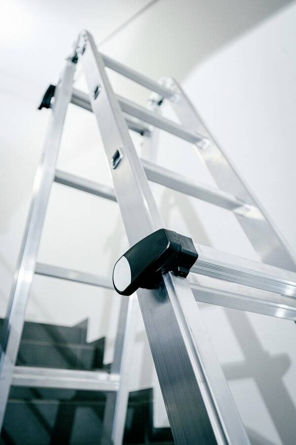 Metall-Leiter steht auf einer Treppe und ist bereit für Zugang zu hoheren Ebenen.