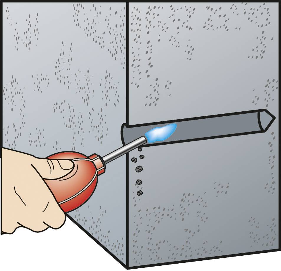 Hand hält Kartusche mit Schweißgerät, erwärmt Metallrohr in einer Wand, erzeugt eine gleichmäßige Schweißnaht.