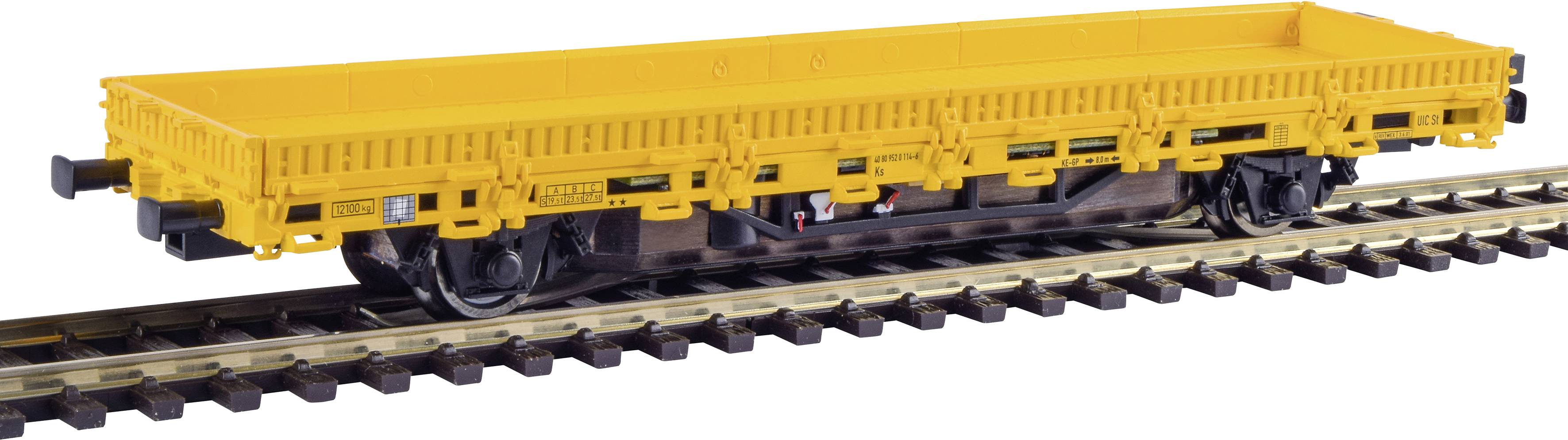 Gelber Güterwaggon auf Schienen für den Transport von schweren Gütern, ohne sichtbare Ladung, auf braunem Gleis.